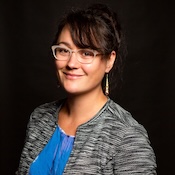 Image of a smiling multiracial woman with black hair in front of a black background