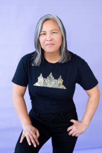 Asian woman stands boldly against purple background